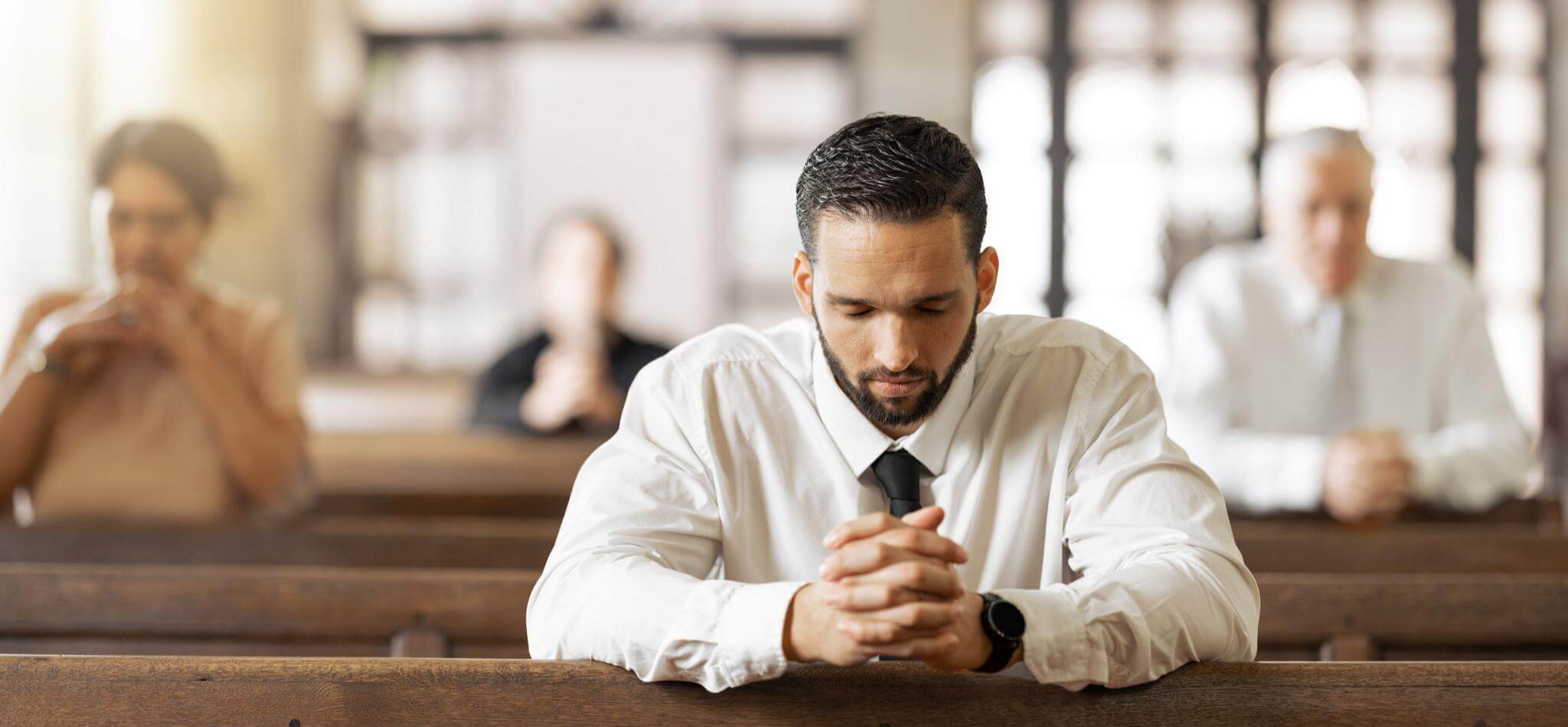 man kneeling praying in church